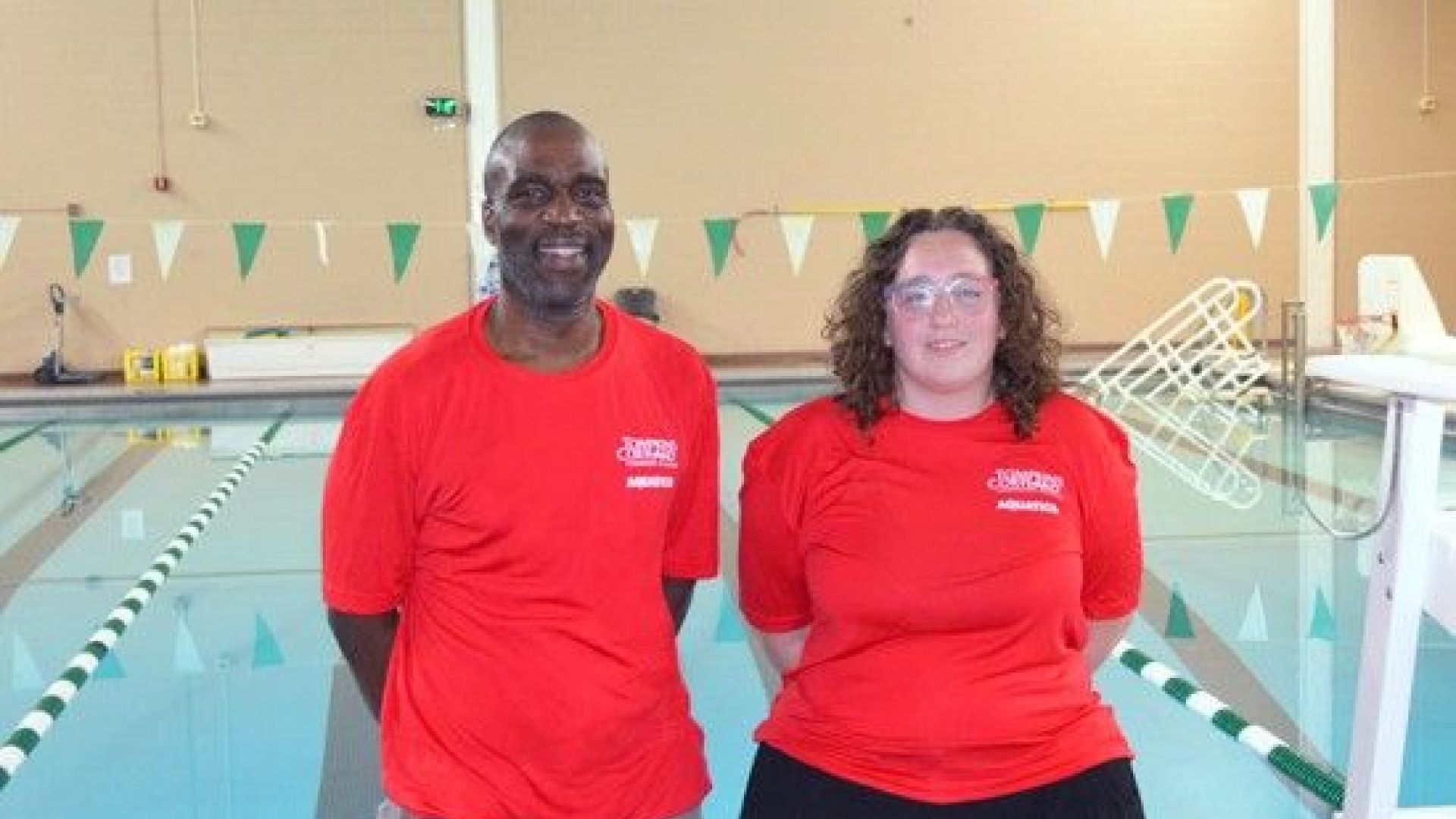 Alfie Okaru and Madisyn Zimmer standing in front of the pool