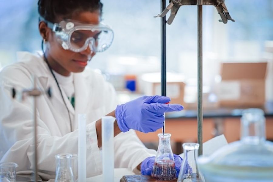 Student working with beakers in lab 