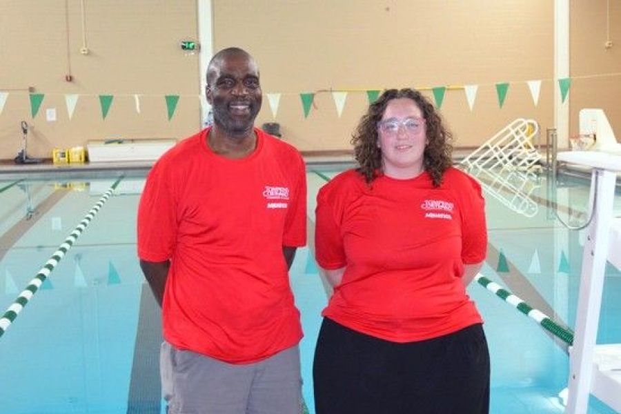 Alfie Okaru and Madisyn Zimmer standing in front of the pool