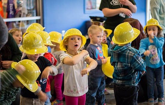 Kids from child care center wearing toy hard hats