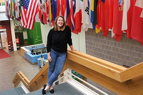 Student standing on stairs in front of flags