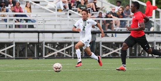Panther soccer player dribbles up the field in front of bleachers